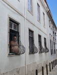 Homme à une fenêtre aux grilles courbées