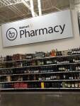 Panneau Walmart Pharmacy au-dessus de rayons de bouteilles