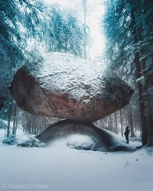 Rocher en équilibre dans une forêt enneigée