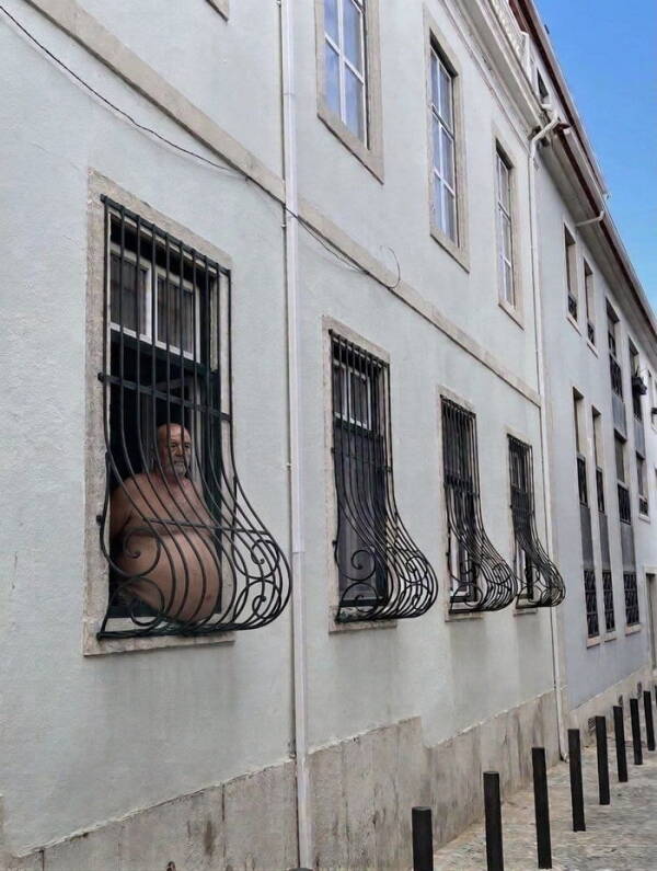 Homme à une fenêtre aux grilles courbées