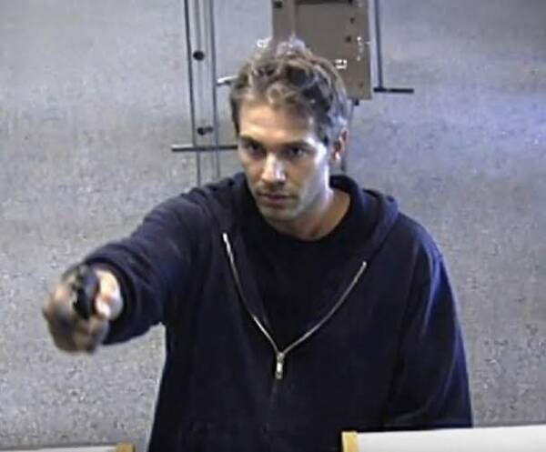 Homme pointant une arme de poing