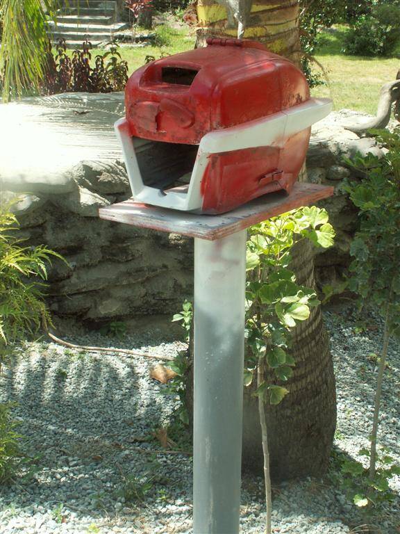 Boîtier rouge sur un socle dans un jardin