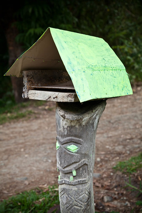 Poteau sculpté au toit vert