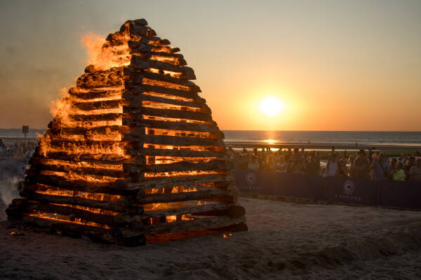 Grand feu sur une plage au coucher du soleil